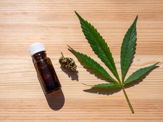 CBD ÖL mit einem Cannabisblatt auf einem Holzhintergrund