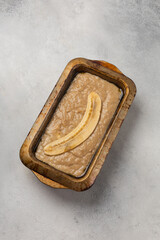 Raw banana bread dough in rectangular shape on light background