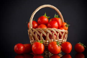 fresh ripe red tomatoes in basket isolated on black