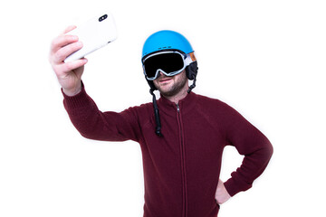Portrait of a brutal man in a ski helmet and glasses who takes a selfie