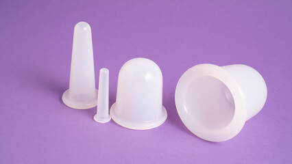 Massage cupping set on purple background. Massage vacuum jars. Silicone cups for vacuum therapy....