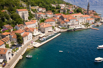 Perast, Boka Kotorska, Montenegro. Drone aerial view of small coastal town with old stone houses under the hills above the Adriatic Sea