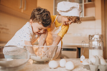 Two little brothers baking at the kitchen