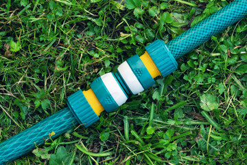 Garden irrigation hoses connected with a modern plastic hose connector for quick connection lying...