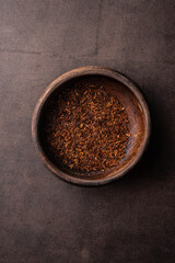 selective focus, natural red leaf tea in a wood bowl