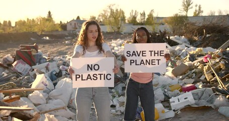 Ecology activists holding signs agains pollution at trash pill