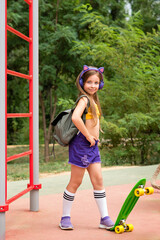 Young child girl posing with skateboard on outdoor. Summer vacation. Leisure entertainment. Full...