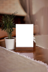 Mock up of restaurant nameplate among restaurant decoration: linen and flowerpot. Place for text. Cozy interior
