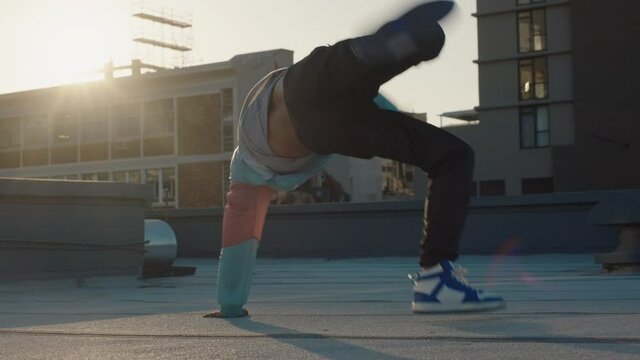 dancing man breakdancing on roof top hip hop dancer practicing dance routine performing freestyle moves in city at sunset