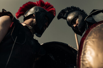 Duel between two ancient warriors in battle dress with shields and spears.