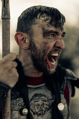 Portrait of screaming in rage ancient Spartan warrior after battle.