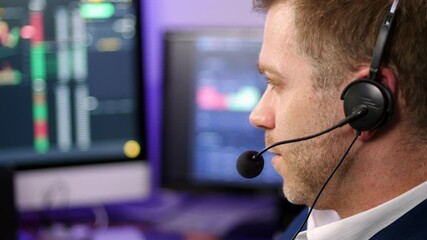 Chatting man in techical support wearing a headset in a trading broker office