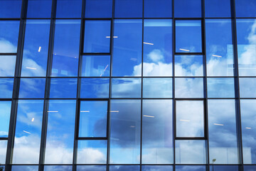 Clouds reflecting off the glass facade of a skyscraper.