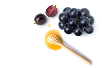 Black grapes with honey dripping isolated on white background. Top view. Flat lay. Copy space.