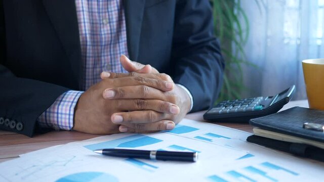 thoughtful man's hand on a financial data on table 