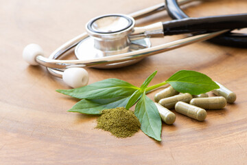 Andrographis paniculata leaf with green powder herbal capsules and medical stethoscope isolated on...