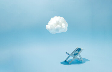 Beach chair in a shade of white cloud with blue background. Minimal concept.