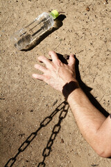 Nagano, Japan, 08-30-2021 , Arm of a man trapped by a chain made of shadows, which represents our...
