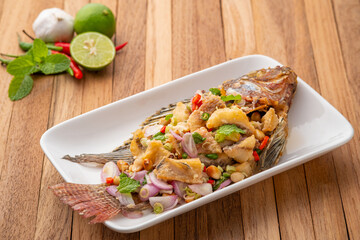 Fried Tilapia with spicy lemongrass salad.Deep fry tilapia fish in lime sauce mix with onion chilli Peanut and sliced lemongrass