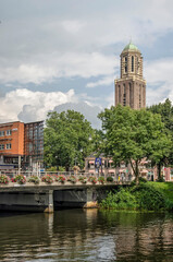 Naklejka premium Zwolle, The Netherlands, August 20, 2021: western entrance to the old town with the iconic Peperbus tower rising above the trees and houses