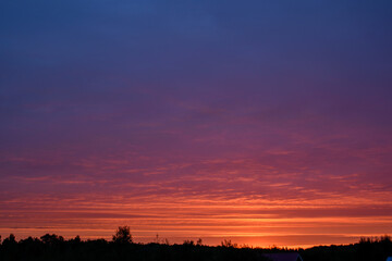 Sunrise turns the clouds pink and red