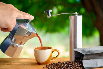 Boran coffee brewing that grinds coffee beans by hand Italian Moka pot with hot cups of coffee and...