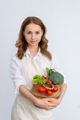 Cute girl with a basket of fresh vegetables