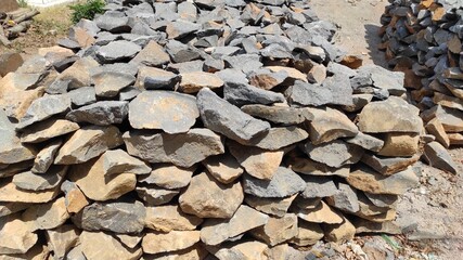 photo of flat stones stacked neatly to form a square on the side of the highway