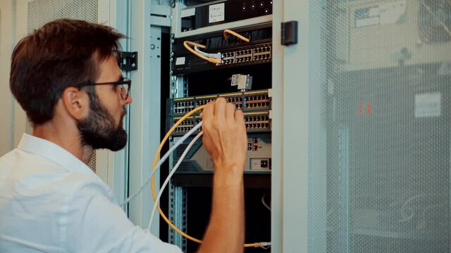 Server IT Engineer In Data Center Server Room.Engineer Working Laptop Computer.Server Room Works.Programmer Checks A work Of Server At A Data Center.	