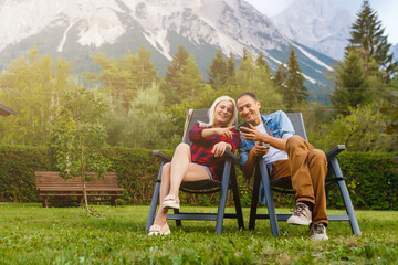 Young lovers relaxing on holiday in beautiful panorama with mountains Bavaria Germany. Couple in love relaxing in spring