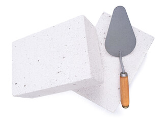 Trowel tool on aerated concrete block isolated at white background. Mason and brick
