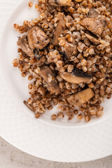 buckwheat porridge with mushrooms on a white plate