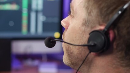 Unrecognizable man in technical support talking on phone headset at trading broker desk.