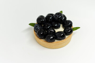 Top view of a tartlet with blueberries on a white background