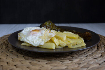 Fried potatoes with fried egg and fried pepper, a highly demanded food in southern Spain. The potatoes should not be frozen, and all homemade. Made all with olive oil. Front view