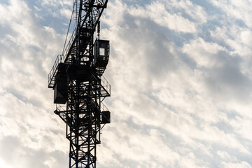  A large fragment of a tower crane against the background of clouds