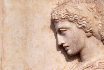 Fototapeta na wymiar Ancient Greek relief of woman on marble wall, copy space for background