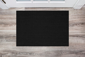Black Coir Doormat on wooden floor in front of the door. Product mockup - 454786202