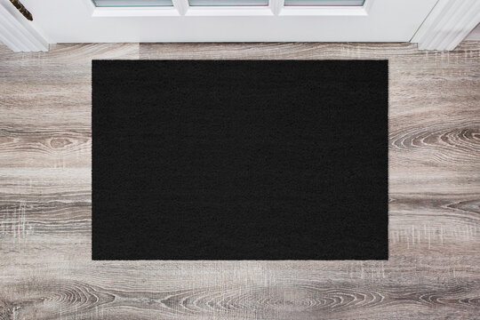 Black Coir Doormat on wooden floor in front of the door. Product mockup