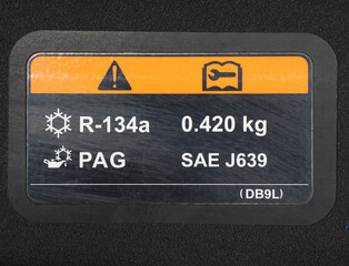 A warning label in a car engine, air compressor. A car maintenance and repair concept. Components of the car concept.
