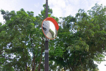 Outdoor convex mirror on roadside of condominium building. Traffic curved glass. Driving safety....