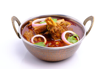 Indian style mutton curry in a copper brass bowl on white background