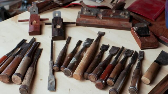 Sliding view of many different equipment on the table: chisels, jack-planes. Jointers shop interior and a workbench. 