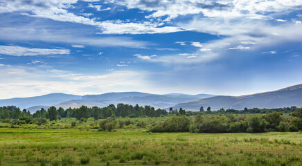 Fototapeta na wymiar Panorama of clouds over the blue hills of Khakassia, Russia.