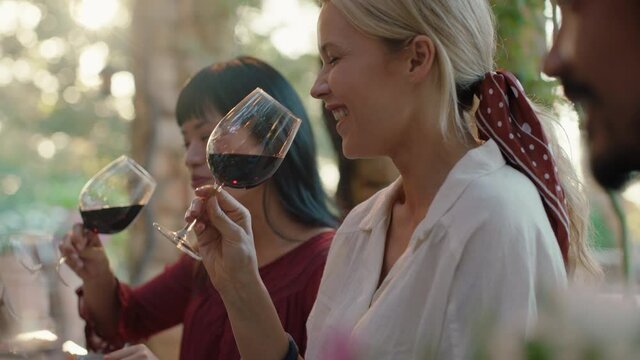 best friends celebrating at dinner party two women drinking wine making toast enjoying summer reunion gathering sitting at table outdoors at sunset 4k