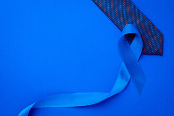 Prostate awareness. Blue ribbon, fashion tie isolated on deep blue background. Awareness prostate...