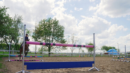 on a ranch in nature, a jockey on a horse jumps over obstacles. High-quality photo