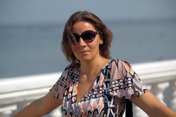 brunette woman in shorts and blouse r on the embankment