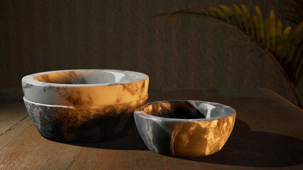 Marble bowls on wooden table, sunset