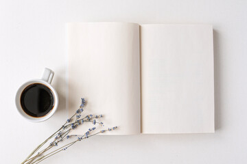 Opened notepad, book with white blank sheets on a desk. Hot black coffee, dry lavender bouquet....